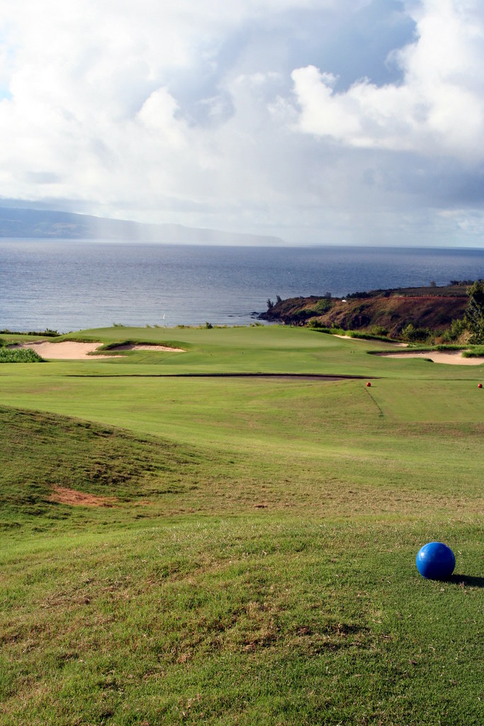 The par-3 11th at Kapalua's Plantation Course on Maui, with a rain shower over the ocean and Molokai in the distance.