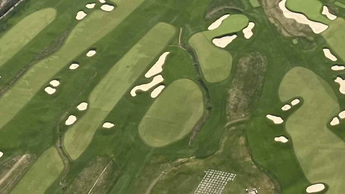 An overhead view of Oakmont's parallel fairways, ringed with white bunkers and crossed by the dark lines of its restored drainage ditches.
