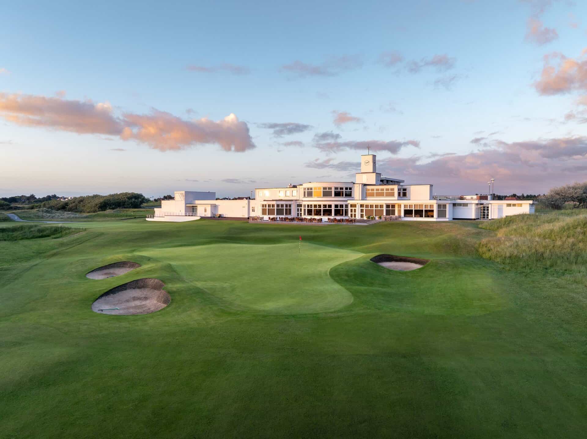Royal Birkdale's 18th green and bunkers in front of the club's white Art Deco clubhouse and clock tower.
